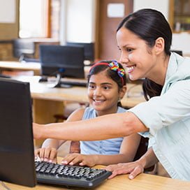 Teacher helping student at computer